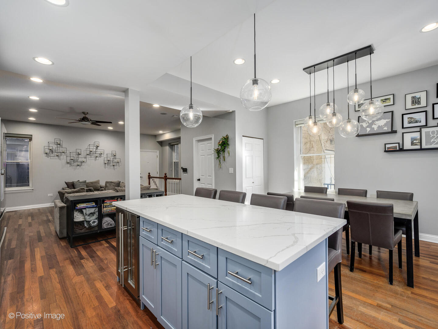1440 North Wood Street, Unit 1R Chicago, IL 60622 - Photo 9 of 22 a large kitchen with kitchen island a stove a table a sink and a dining table with wooden floor