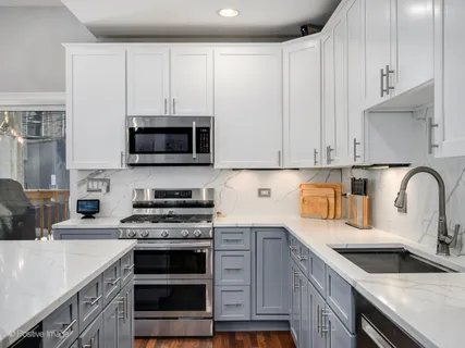 a kitchen with granite countertop a stove a sink and a microwave