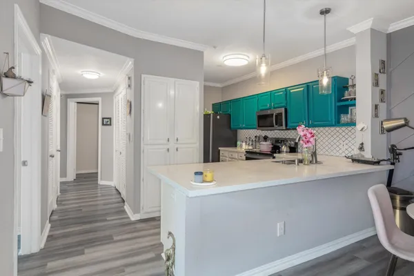 a view of kitchen with sink microwave refrigerator and furniture