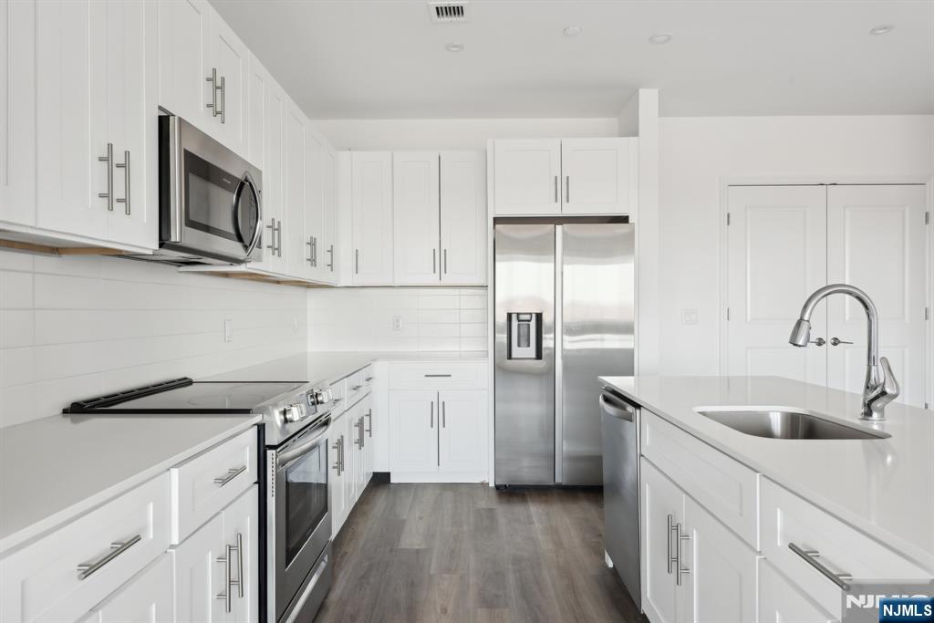 2 Executive Drive, Unit 809 Fort Lee, NJ 07024 - Photo 8 of 11 a kitchen with stainless steel appliances granite countertop white cabinets a sink and dishwasher