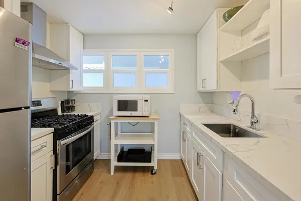 a kitchen with a stove sink and cabinets