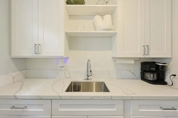 a kitchen with white cabinets and a sink