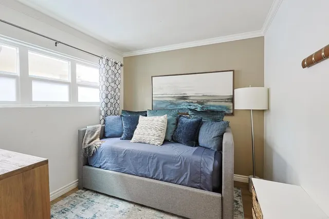 a living room with a couch and a dresser next to a window