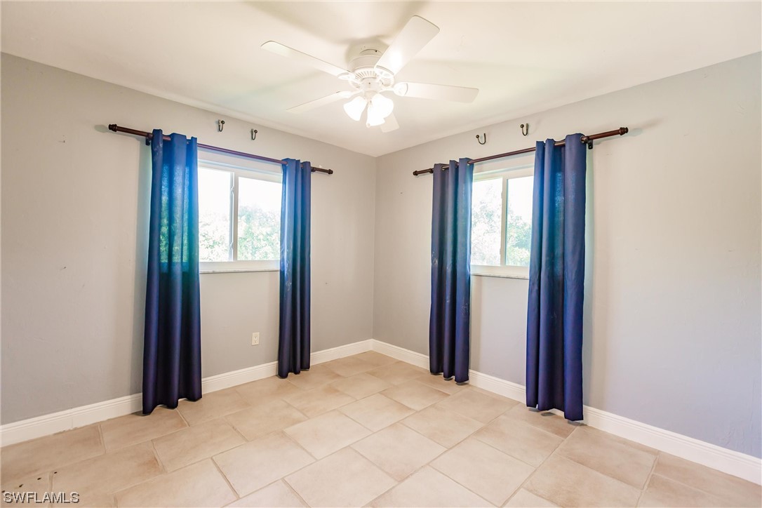 72 Pebble Beach Boulevard Naples, FL 34113 - Photo 11 of 15 a view of a room with a ceiling fan and a window