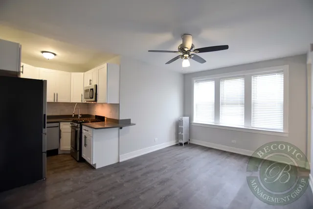a kitchen with granite countertop a stove a sink and a refrigerator