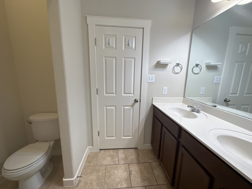 2101 Rivers Edge Way, Unit 32 Austin, TX 78741 - Photo 11 of 22 a view of bathroom with a toilet sink and mirror