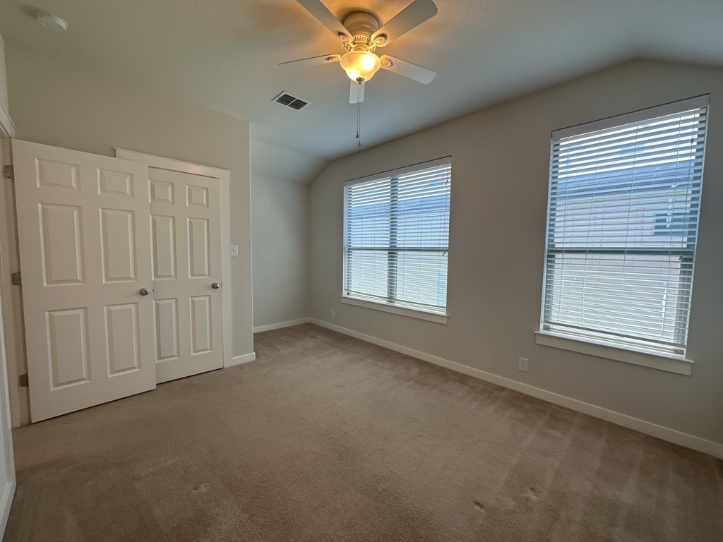 2101 Rivers Edge Way, Unit 32 Austin, TX 78741 - Photo 14 of 22 an empty room with windows and chandelier fan