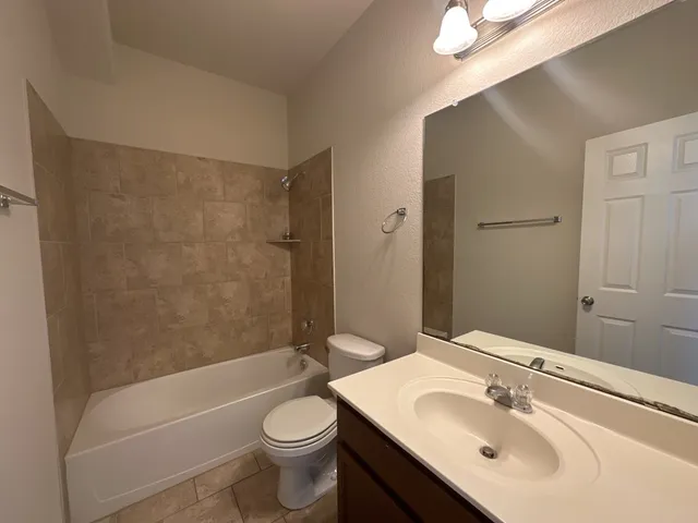 a bathroom with a sink mirror toilet and bathtub