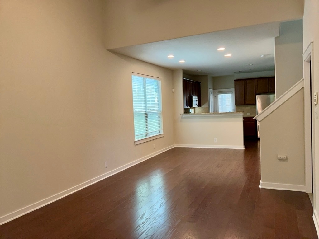 2101 Rivers Edge Way, Unit 32 Austin, TX 78741 - Photo 4 of 22 an empty room with wooden floor and windows