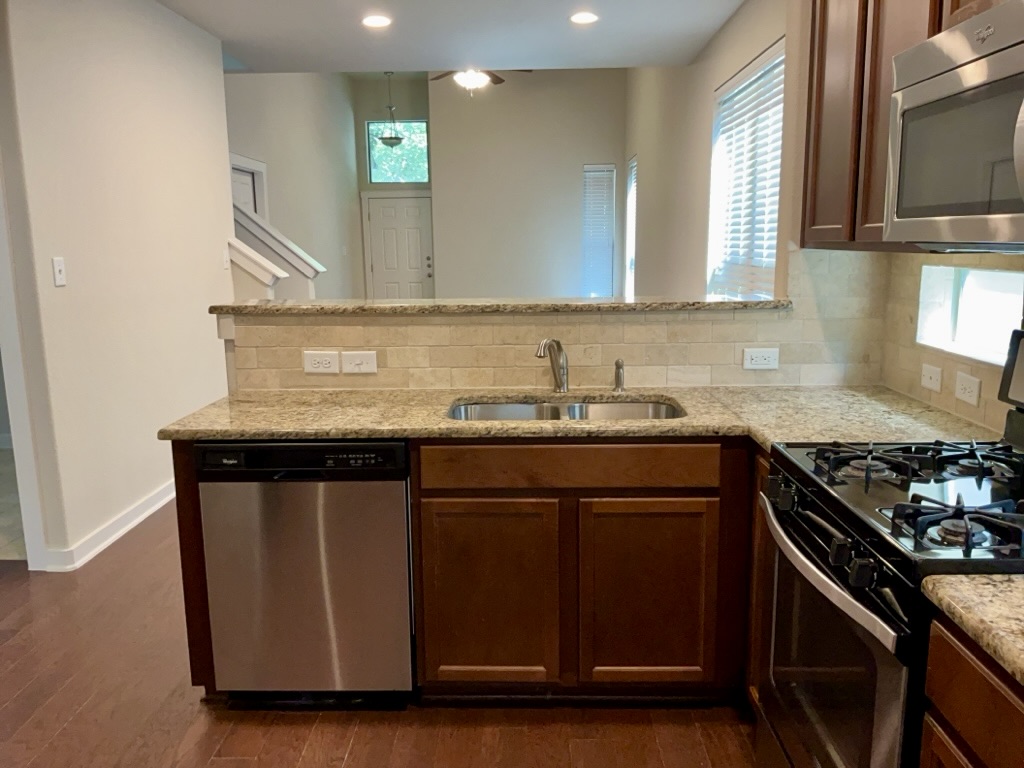 2101 Rivers Edge Way, Unit 32 Austin, TX 78741 - Photo 6 of 22 a kitchen with granite countertop a sink cabinets and stainless steel appliances