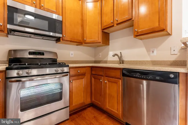 a kitchen with stainless steel appliances granite countertop a sink stove and microwave