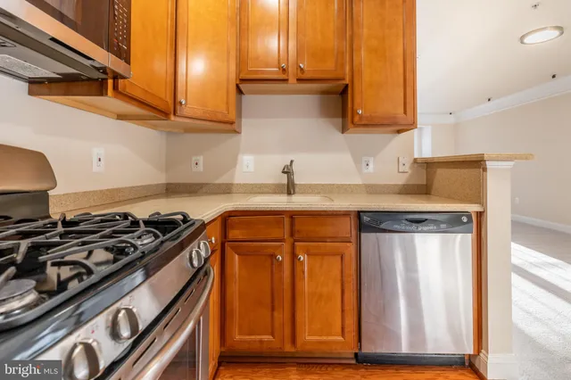 a kitchen with stainless steel appliances granite countertop a stove a microwave and a refrigerator