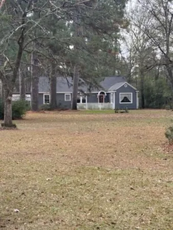 a front view of a house with a yard and trees