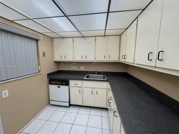 a kitchen with stainless steel appliances granite countertop a sink a stove and white cabinets