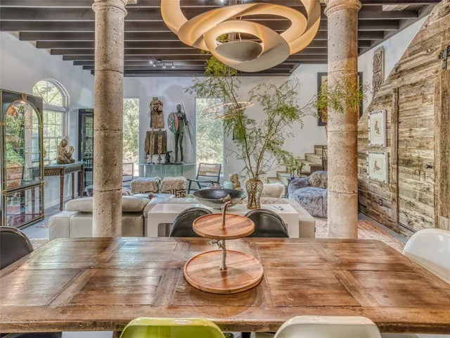 a room with lots of white furniture and a large window