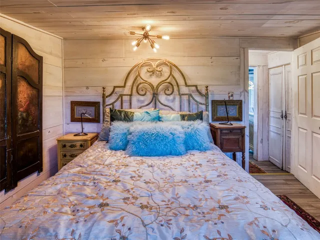 a large bedroom with a bed and a flat tv screen on the dresser