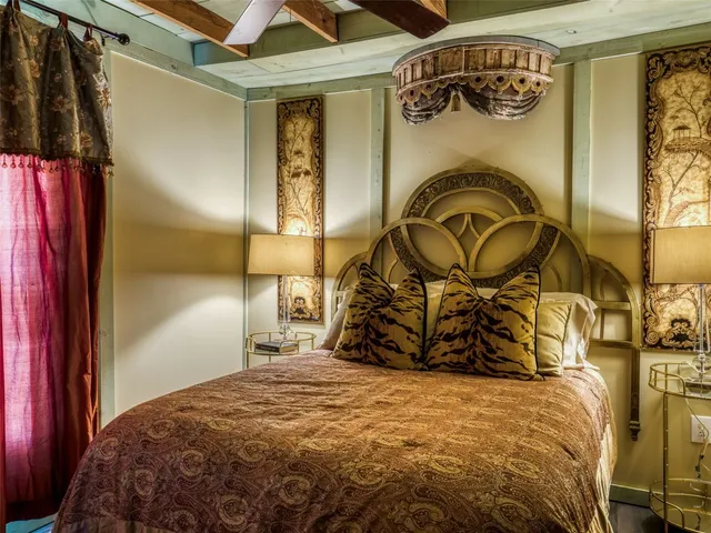 a bedroom with a bed and dresser with mirror