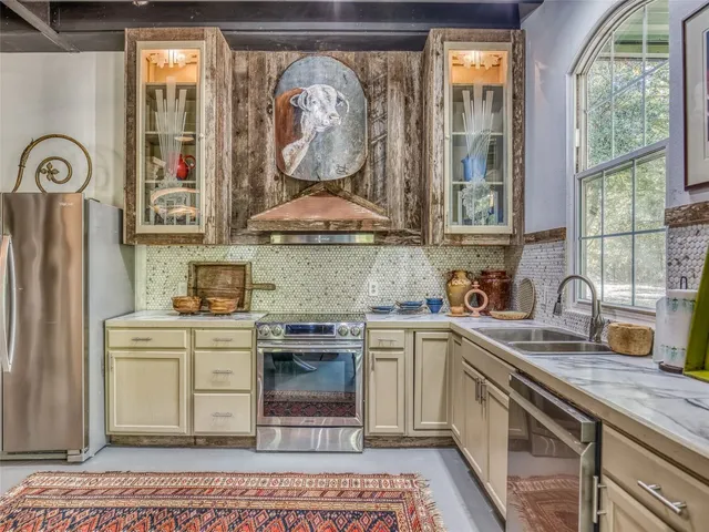 a kitchen with stainless steel appliances granite countertop a sink and a stove