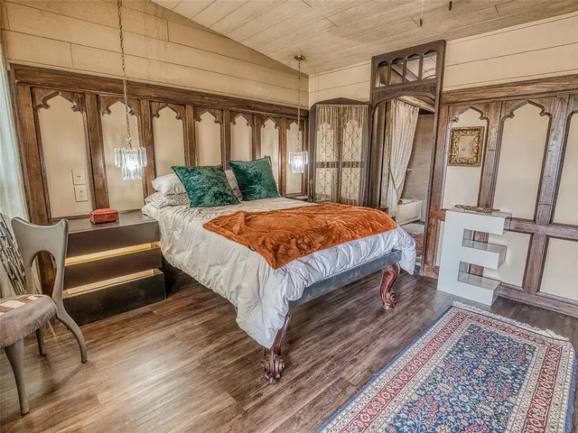 a bedroom with a bed wooden floor and a rug