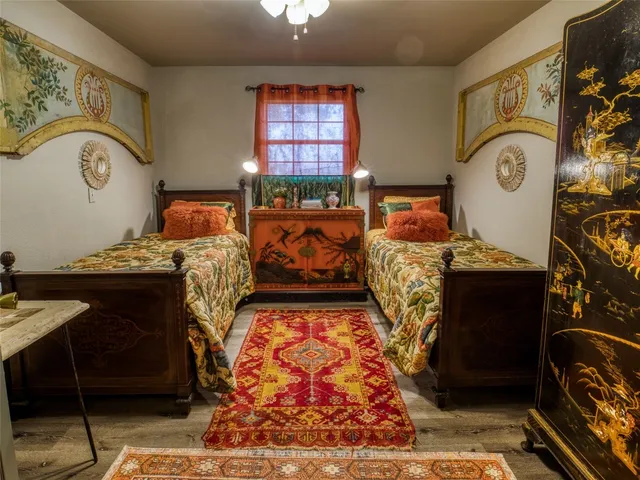 a bed room with two bed and a painting on the wall