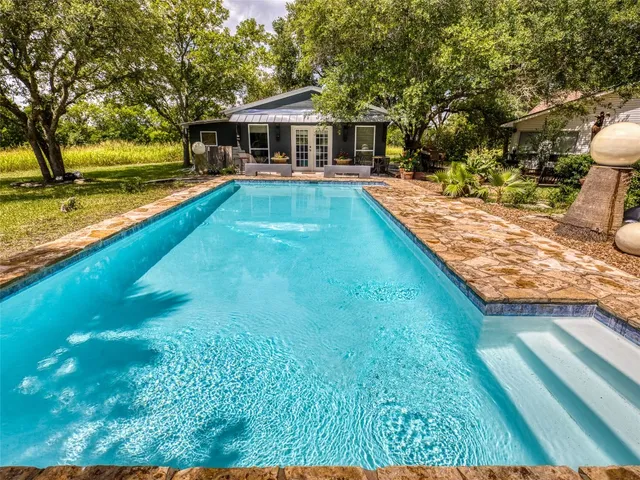 a view of a house with pool and yard