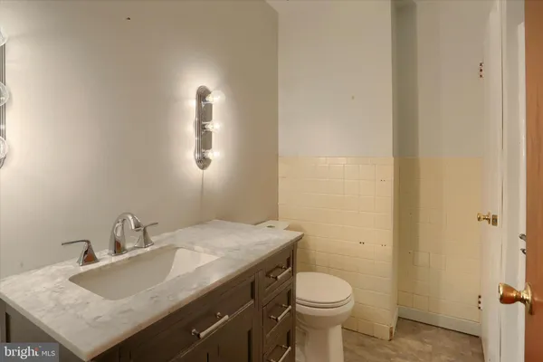 a bathroom with a granite countertop sink toilet and mirror