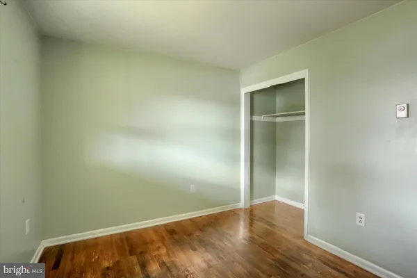 an empty room with wooden floor and closet