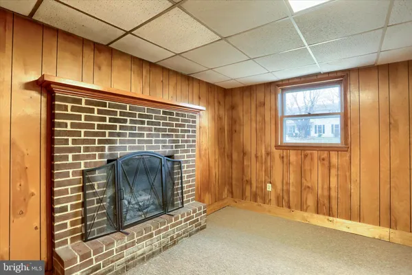 a view of an empty room with a fireplace and a window