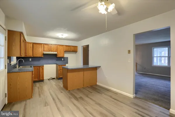 a kitchen with stainless steel appliances granite countertop a refrigerator a stove top oven a sink and dishwasher with wooden floor