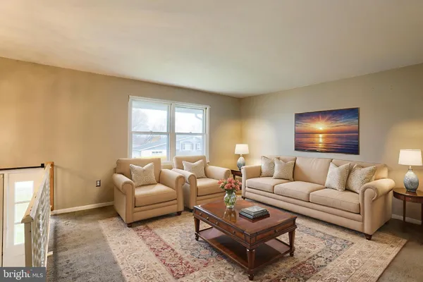 a living room with furniture a rug and a window