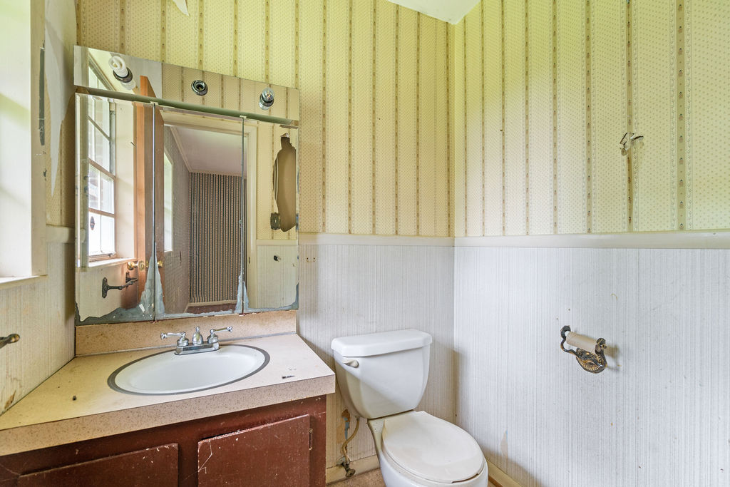 712 Whitney Way Anderson, SC 29625 - Photo 22 of 31 An aged vanity with an integrated sink complements the traditional wallpaper and wainscoting.