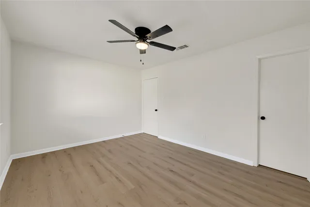 a view of empty room with wooden floor