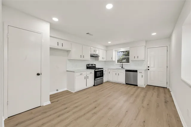 a kitchen with white cabinets and white appliances