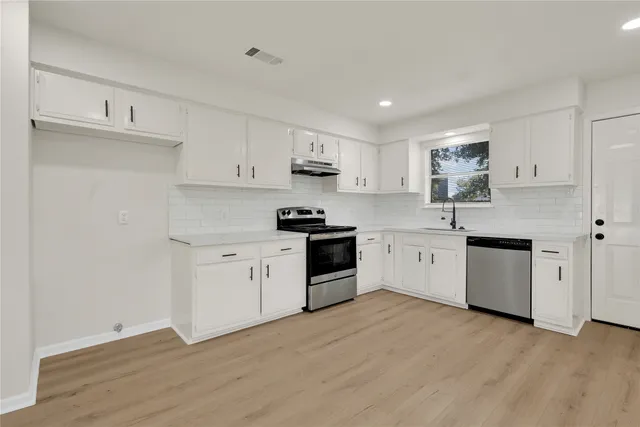 a kitchen with granite countertop white cabinets and white appliances