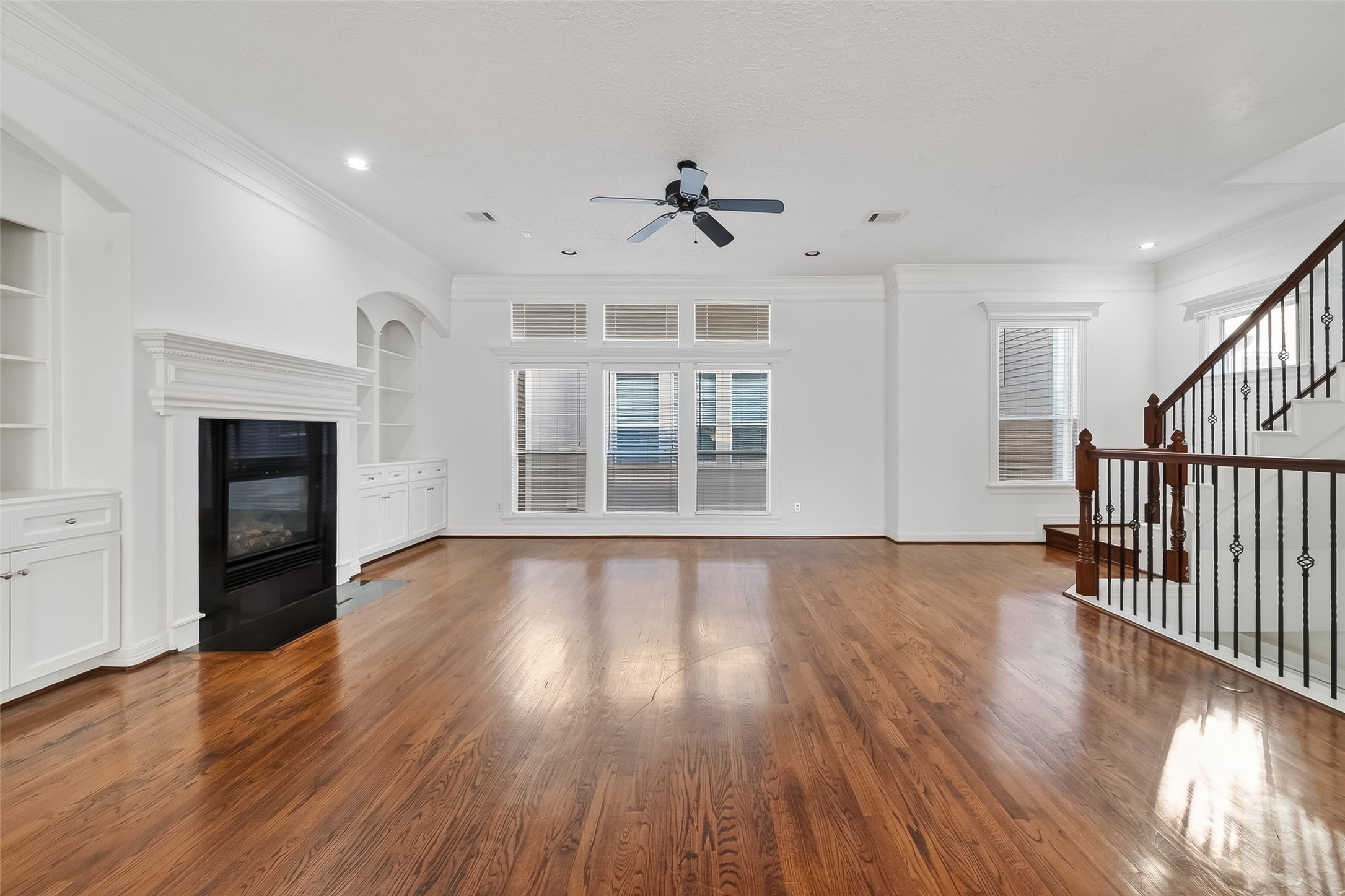 1002 West 22nd Street Houston, TX 77008 - Photo 7 of 43 an empty room with wooden floor fireplace and windows