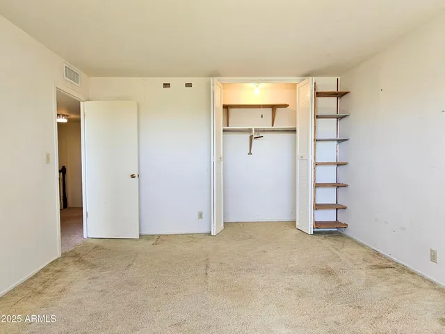 an empty room with wooden floor and white walls