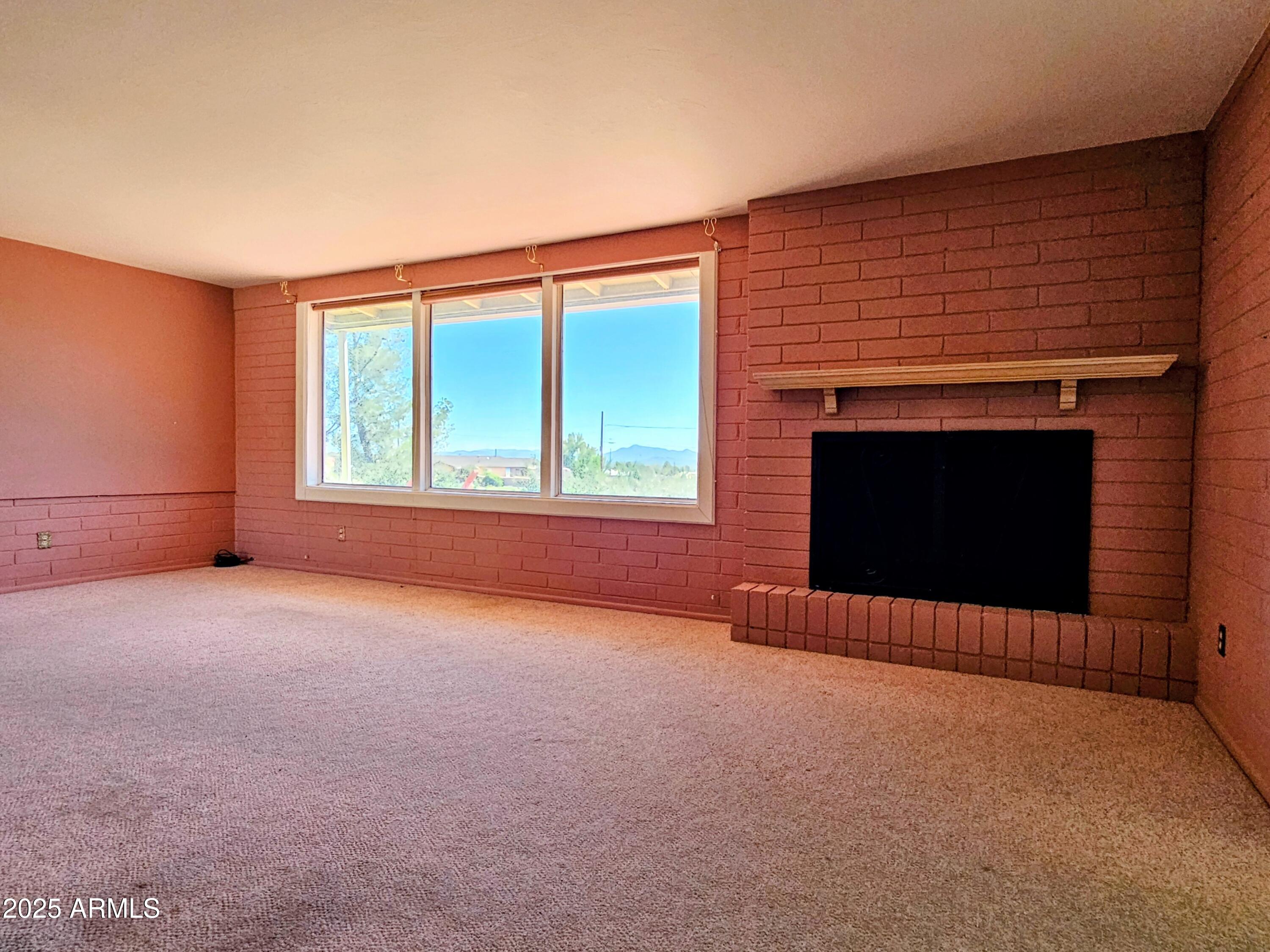 85 Pima Drive Bisbee, AZ 85603 - Photo 7 of 44 an empty room with windows and fireplace