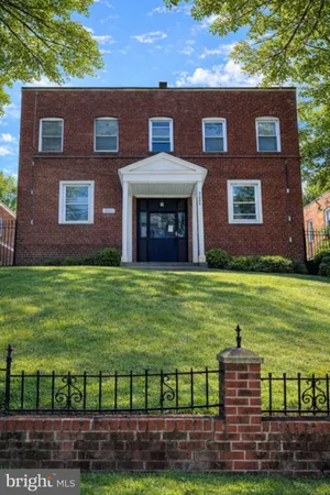 a view of a brick building next to a yard with big yard