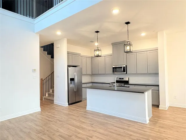 a kitchen with stainless steel appliances granite countertop a sink a refrigerator and a stove