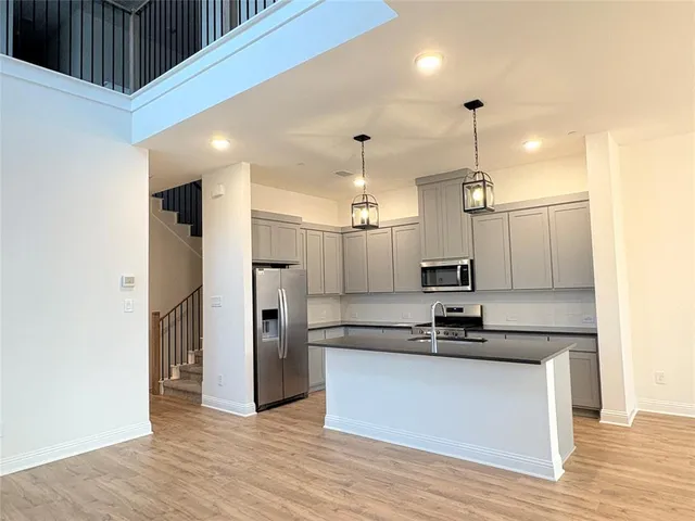 a view of a kitchen with a sink stainless steel appliances and cabinets