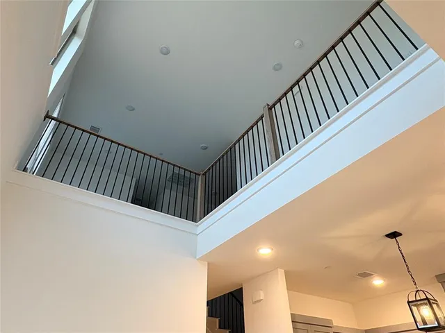 a view of staircase with railing and white walls