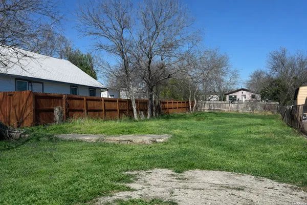 a view of a backyard with wooden fence