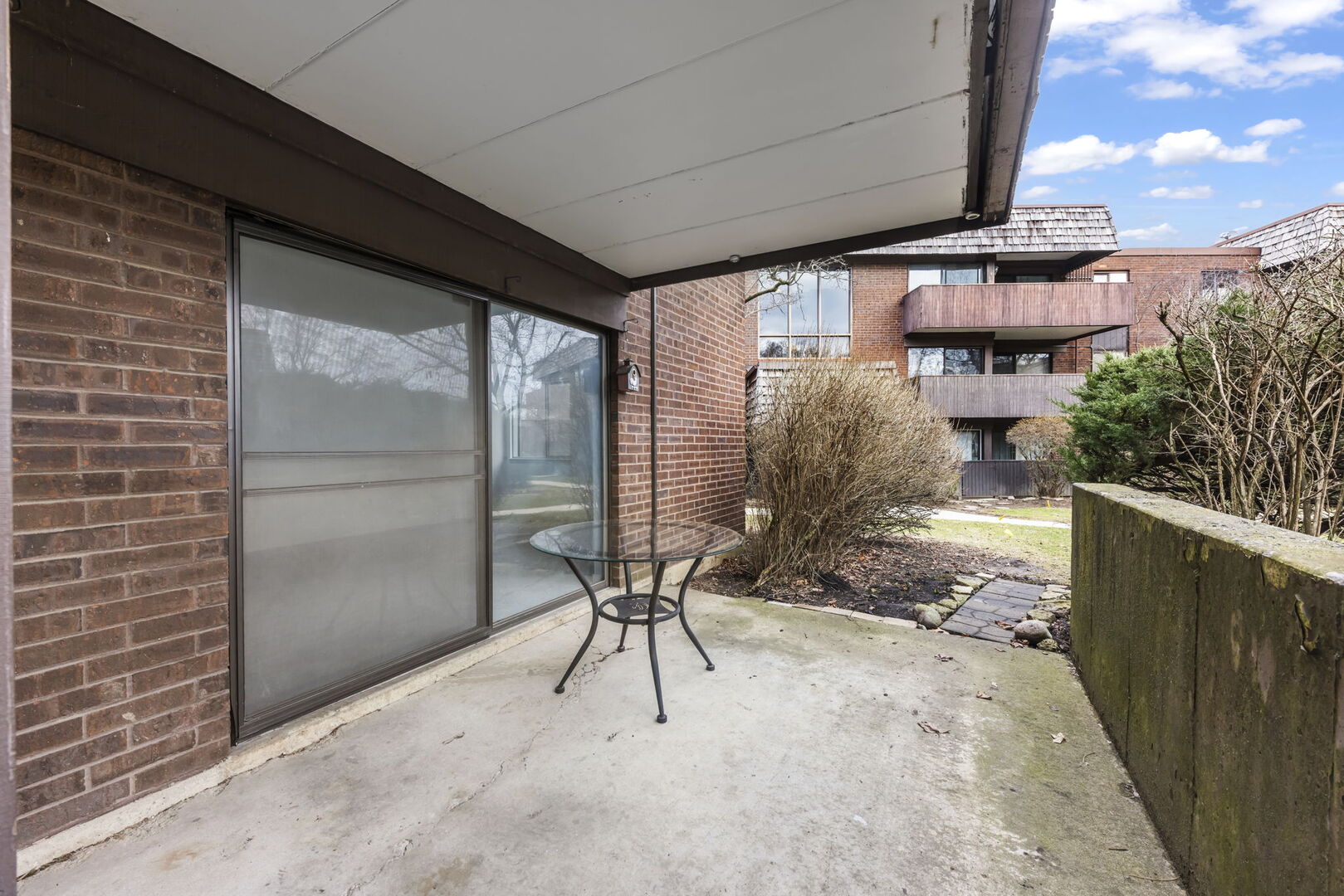 548 Timber Ridge Drive, Unit 108 Carol Stream, IL 60188 - Photo 12 of 18 a view of a porch with a table and chairs
