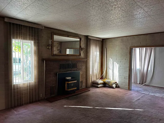 a living room with a fireplace and a large window