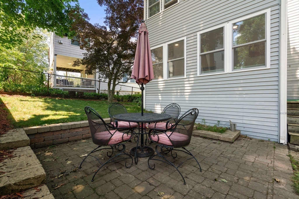 18 Moulton Road, Unit 1 Arlington, MA 02476 - Photo 14 of 16 a backyard of a house with table and chairs