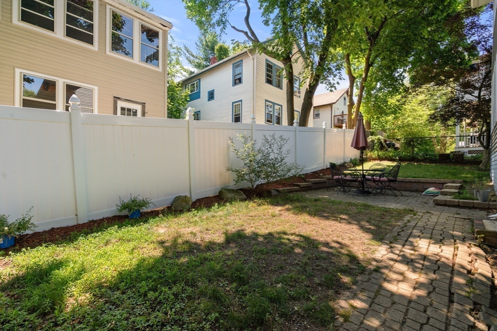 18 Moulton Road, Unit 1 Arlington, MA 02476 - Photo 15 of 16 a white house that has a tree in front of it