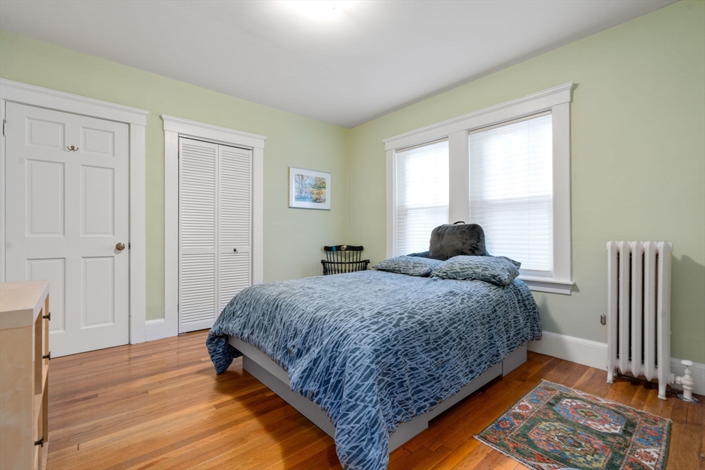 18 Moulton Road, Unit 1 Arlington, MA 02476 - Photo 9 of 16 a bedroom with a bed and wooden floor