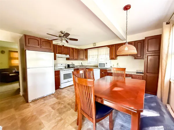 a kitchen with stainless steel appliances granite countertop a refrigerator a oven a sink dishwasher and a dining table with wooden cabinet