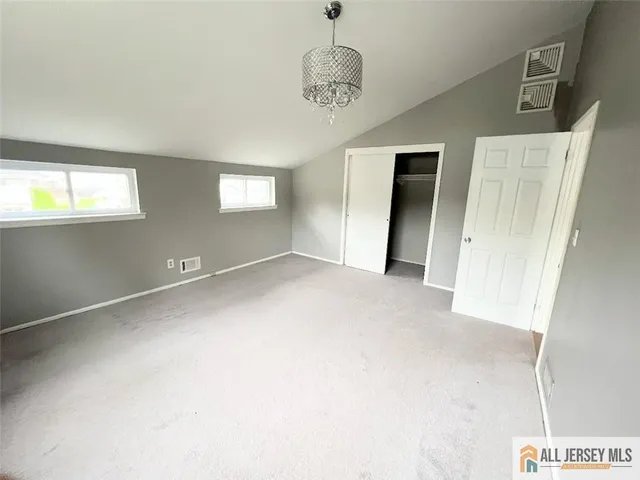 an empty room with windows and closet