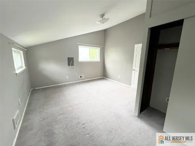 an empty room with windows and closet